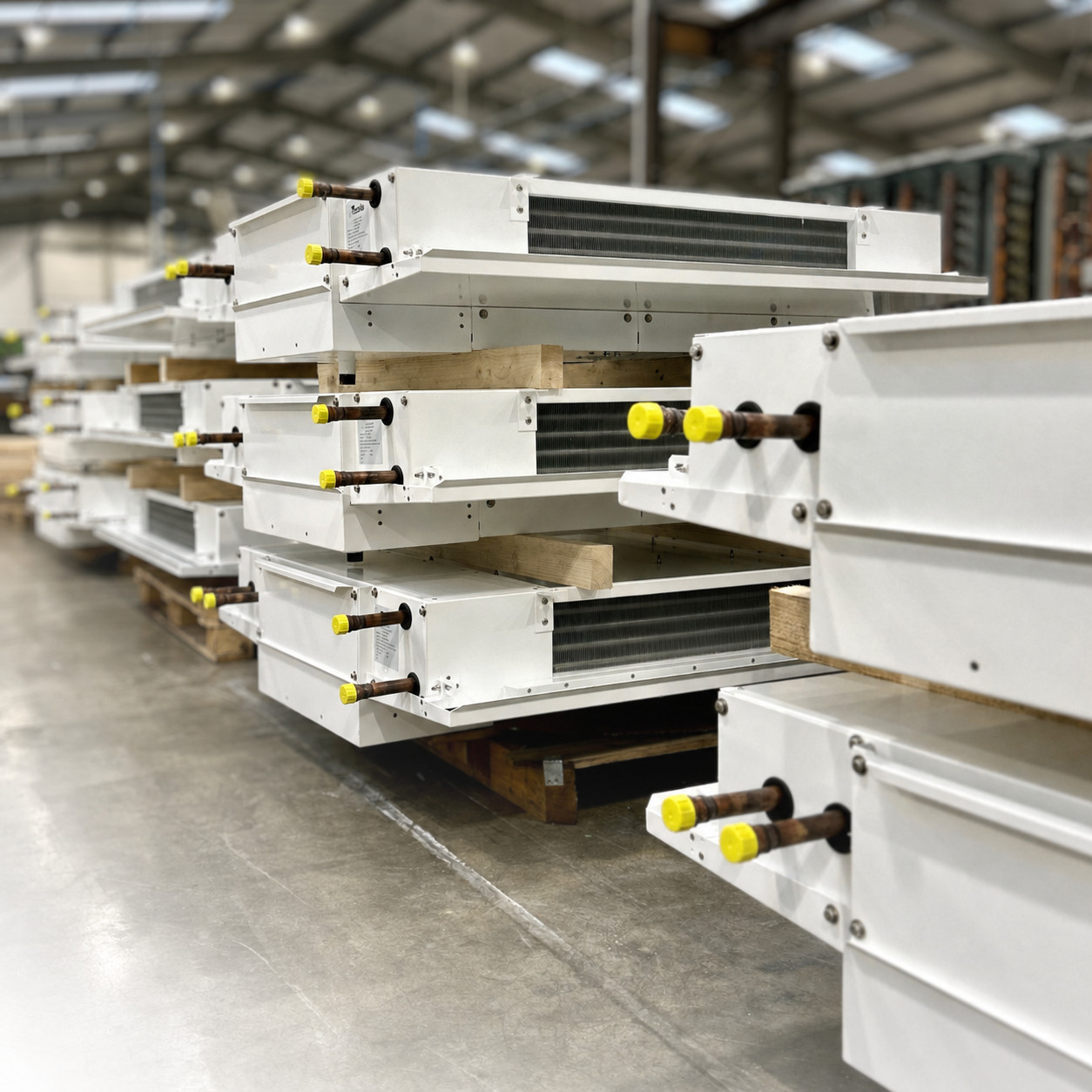 Bespoke dual discharge cooler coils stacked on the HC Coils factory floor