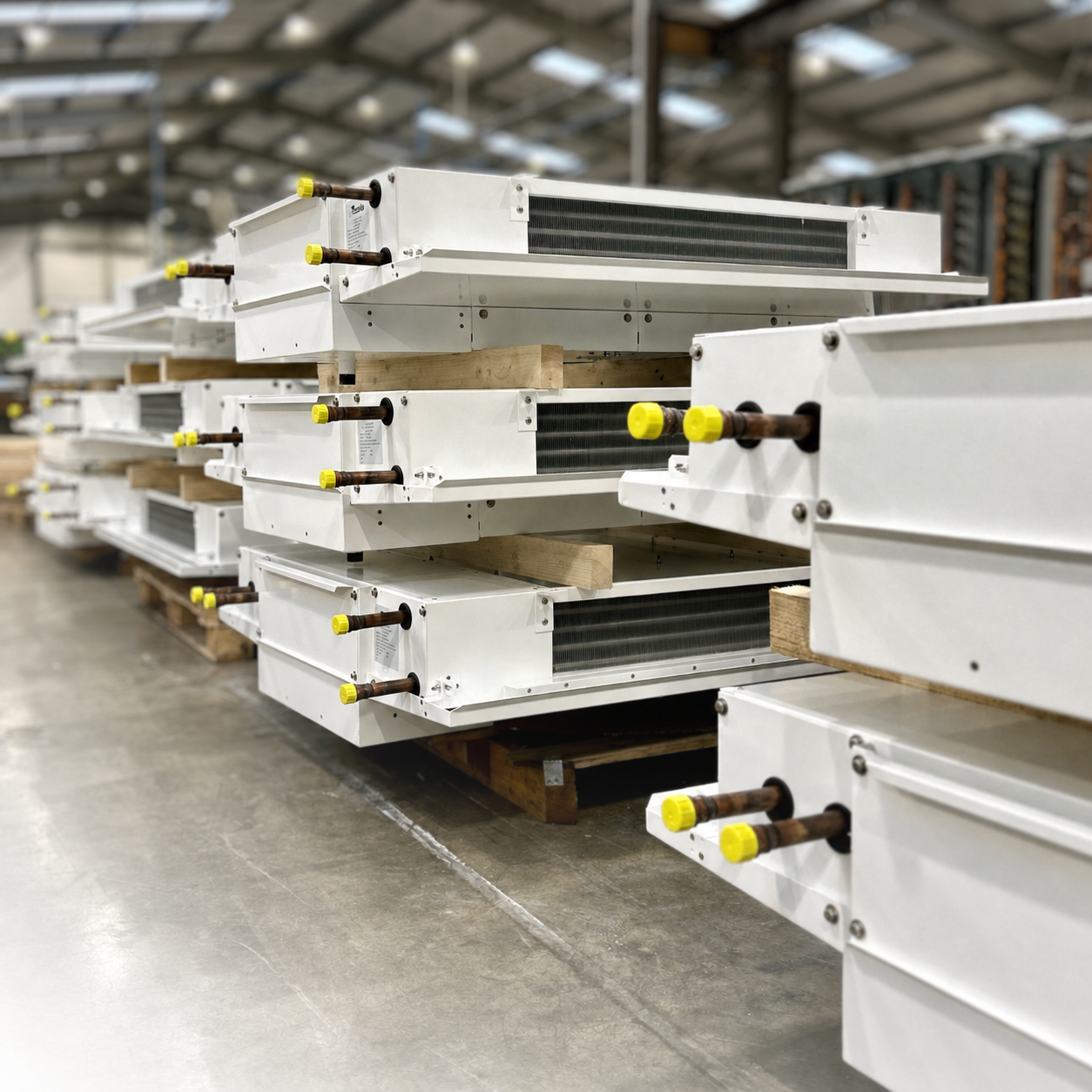 Bespoke dual discharge cooler coils stacked on the HC Coils factory floor