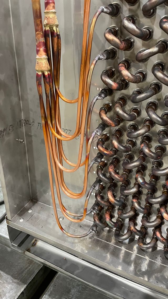 Close-up of copper distributor pipework and return bends on a bespoke DX coil