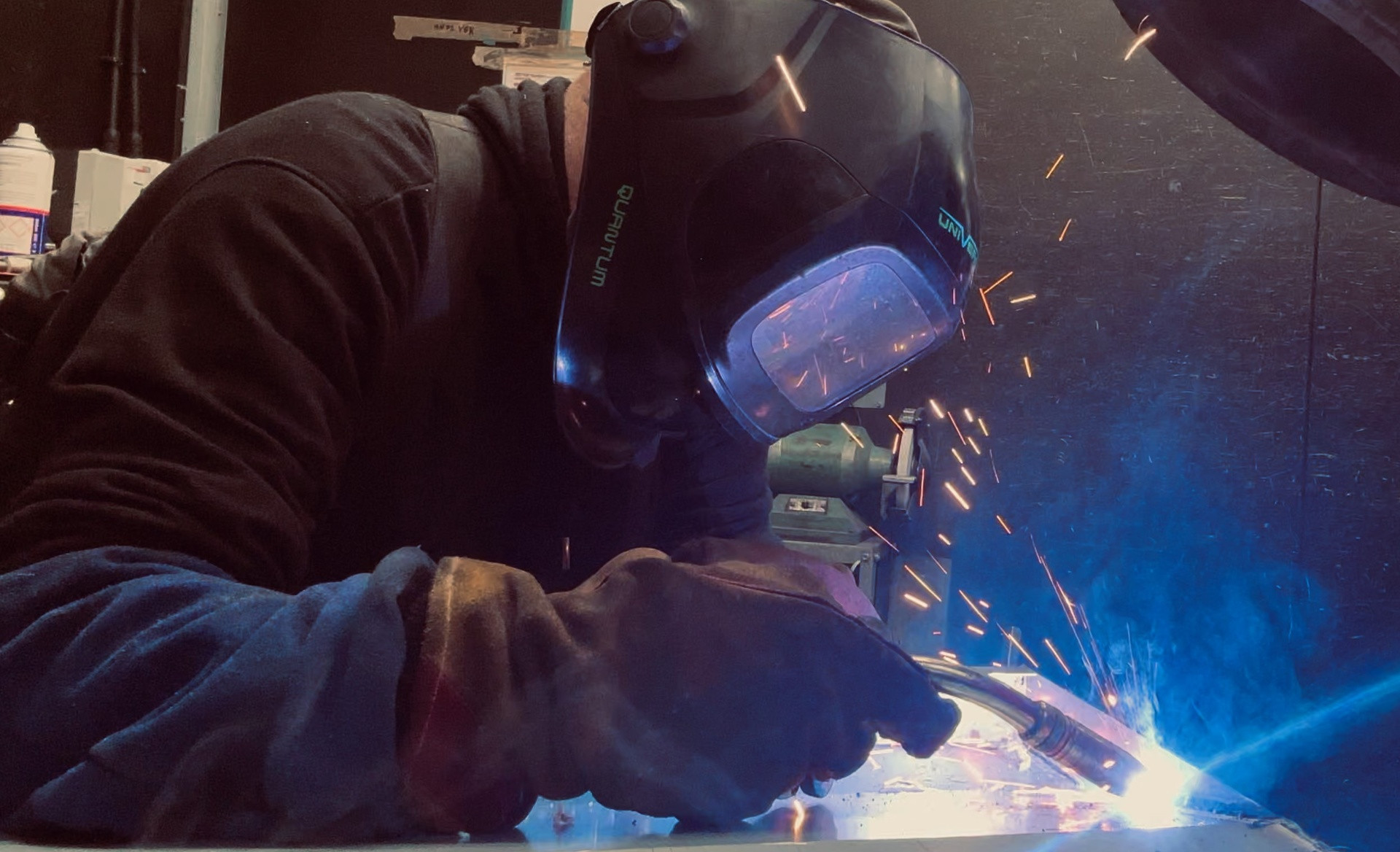 HC Coils welder MIG welding a coil casing with dramatic blue arc and sparks