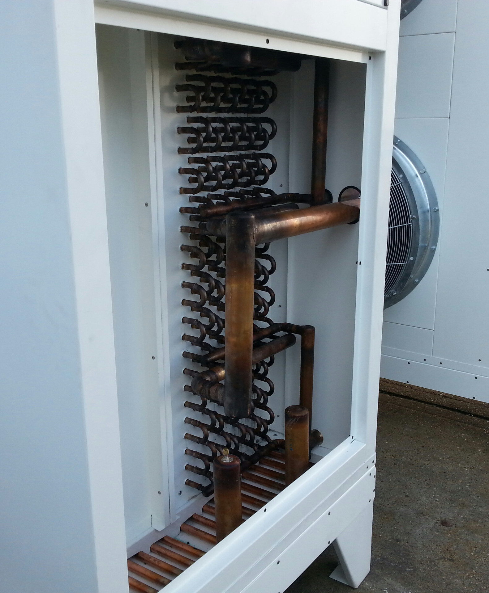 Close-up of copper coil and header assembly inside a floor mounted cooler