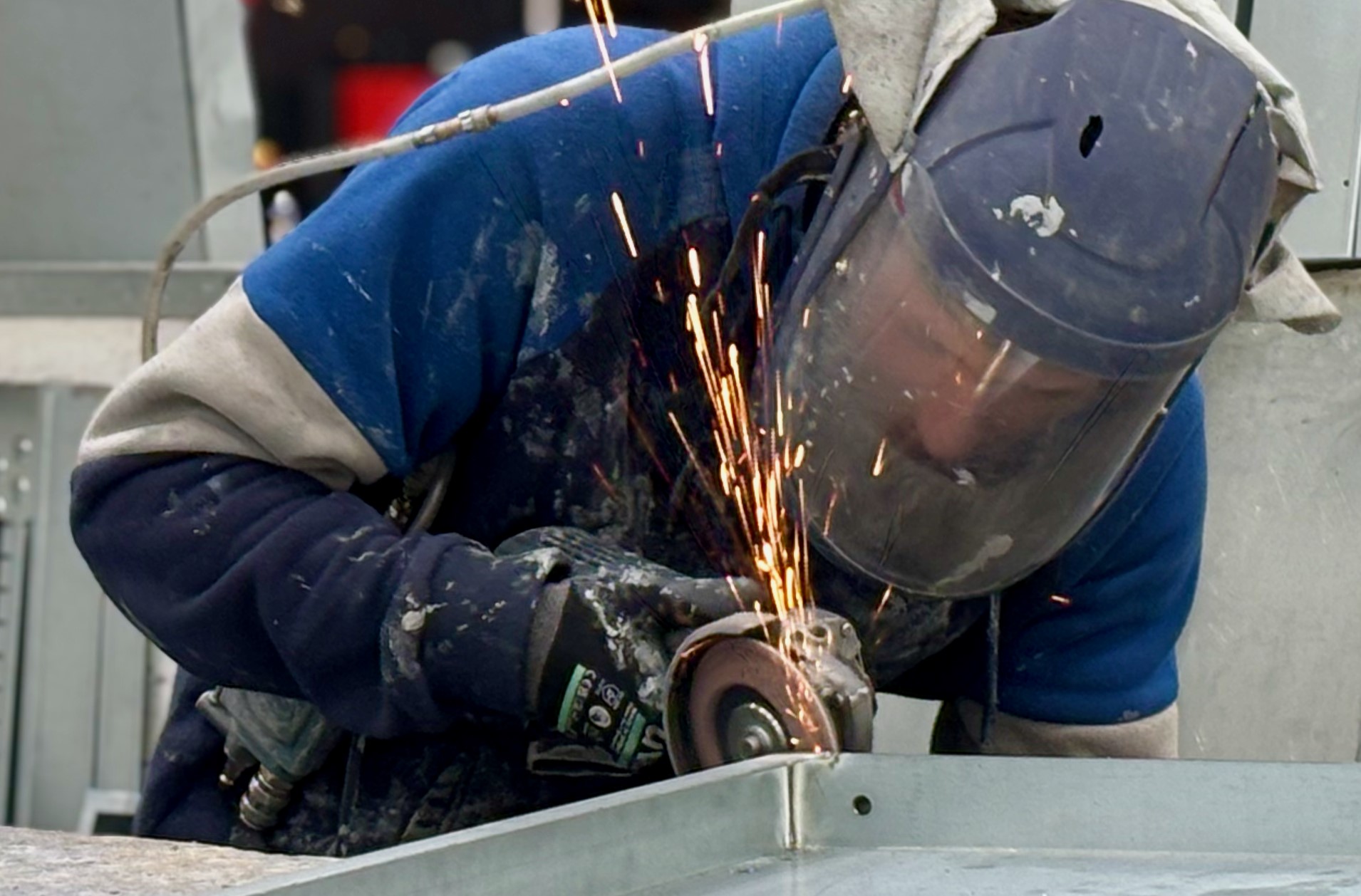 Fabricator grinding a welded steel casing