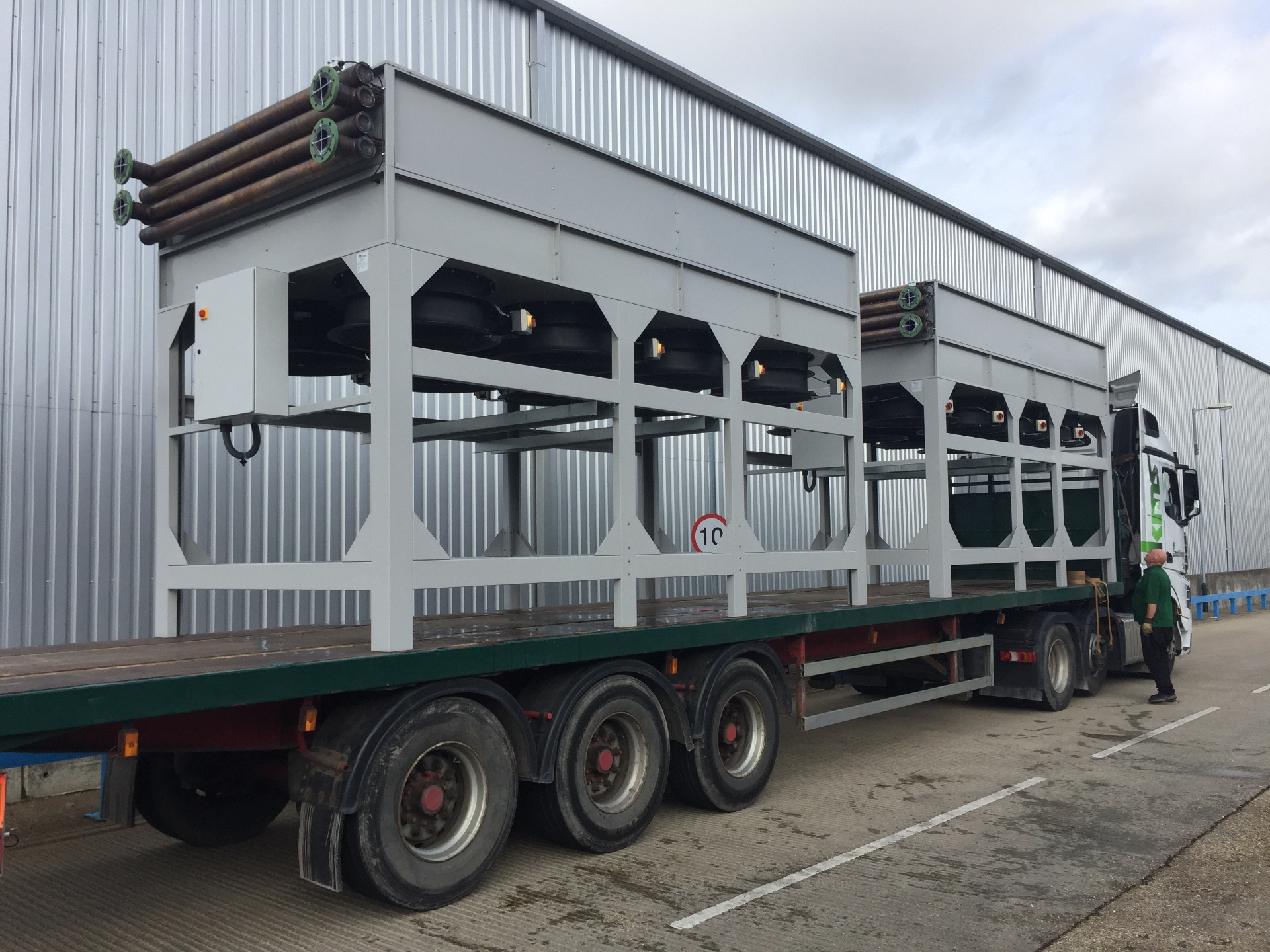 Two large vertical air flow dry air coolers loaded on a flatbed trailer ready for delivery