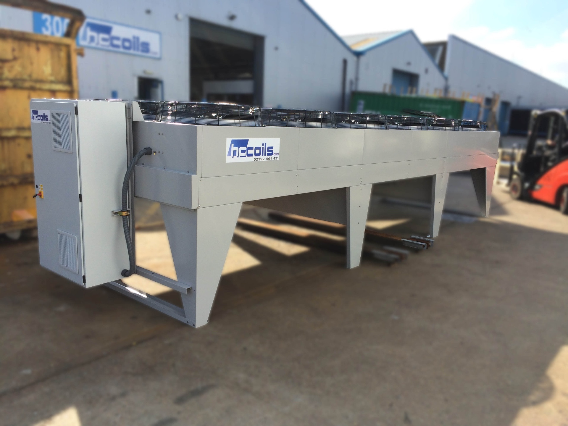 Long vertical air flow dry air cooler with integrated control panel outside HC Coils factory